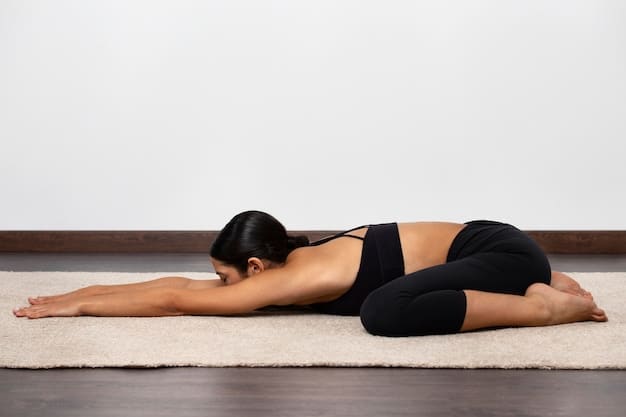 A close-up of a person's back in a forward fold yoga pose (Uttanasana), illustrating spinal lengthening and hamstring stretching.