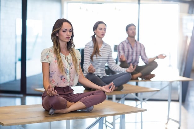 A side view of a yoga instructor guiding a class, demonstrating proper breathing technique during a seated meditation pose. The students are following along, eyes closed, with peaceful expressions.