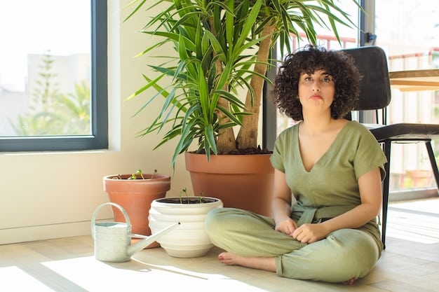A person sitting comfortably in a chair with their eyes closed, practicing mindfulness meditation. There is a soft light and a peaceful ambiance in the room. They are holding their hands gently in their lap.