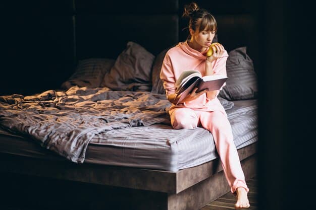 A cozy bedroom with dim lighting, blackout curtains, and a comfortable-looking bed. A book is open on the nightstand, suggesting a relaxing bedtime routine.