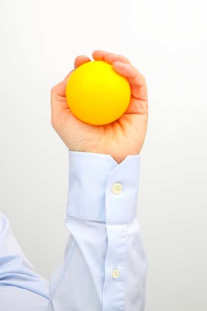 A close-up of a person's hands holding a stress ball, symbolizing stress relief and management. Backlit for emphasis.