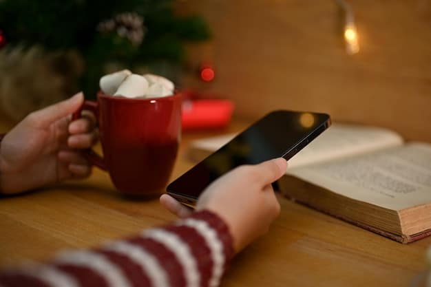 A person calmly using a budgeting app on their smartphone while sitting in a cozy armchair during the holiday season, with a cup of hot cocoa and a Christmas tree in the background.