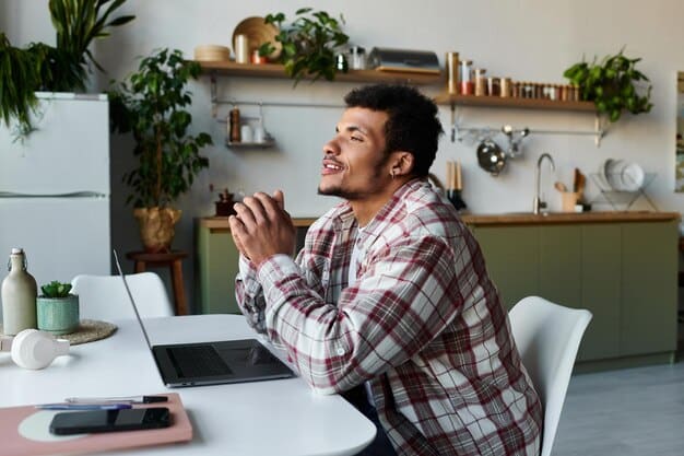A person smiling and looking relaxed while sitting at a desk with a gratitude journal and a pen, showcasing the emotional benefits of gratitude.