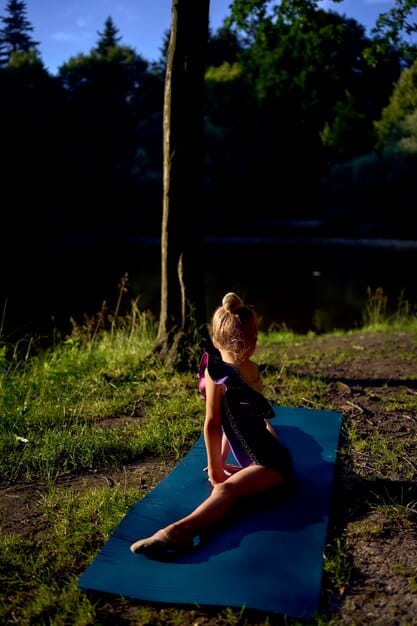 A person practicing yoga outdoors at sunrise, emphasizing the tranquility and beneficial practice of combining mindfulness with physical activity to reduce stress and improve well-being during the time change.