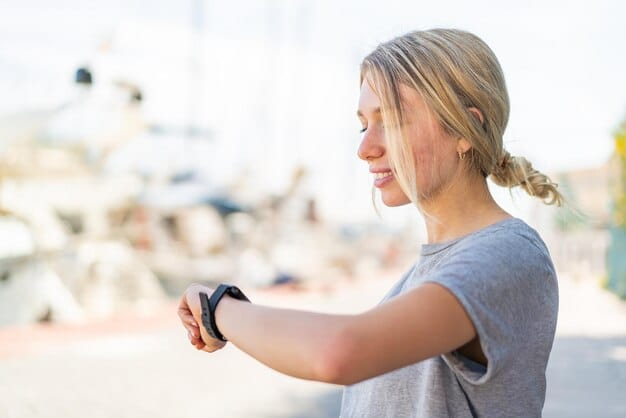 A close-up shot of a smartwatch displaying HRV (Heart Rate Variability) data, with a blurred background of a person practicing yoga in a park.