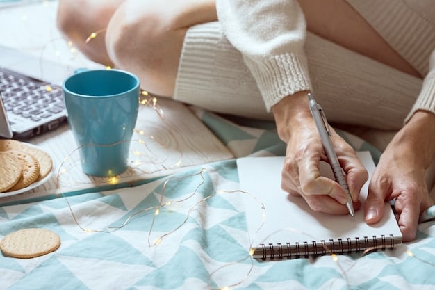 A person writing a habit stacking statement in a notebook, with a pen and other planning tools nearby, emphasizing the importance of mindful planning and preparation.