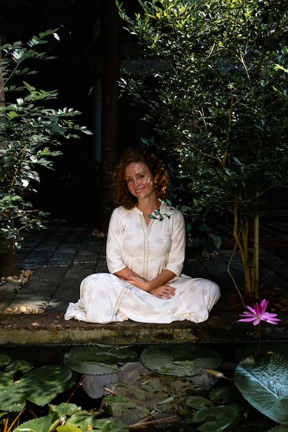 An image of a person sitting in a peaceful garden, meditating with a serene and contemplative expression, symbolizing inner reflection and emotional healing.