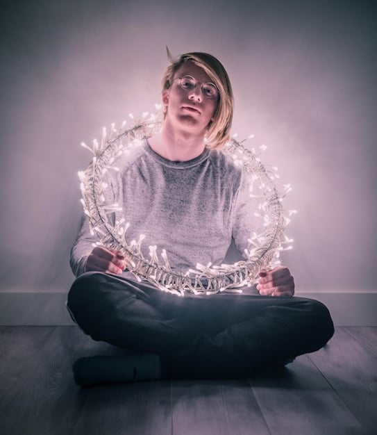 A person sitting in a lotus position, meditating with a glowing light around them, symbolizing inner peace and intuition.