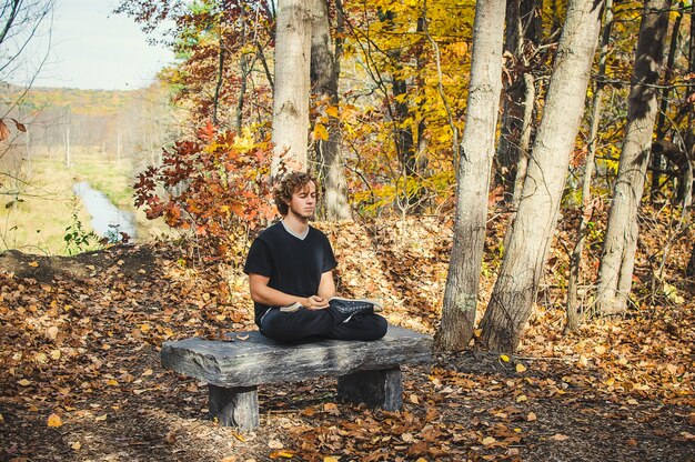 A person sitting in a Zen garden at their workplace, meditating peacefully during a break, surrounded by meticulously raked gravel and carefully placed rocks.