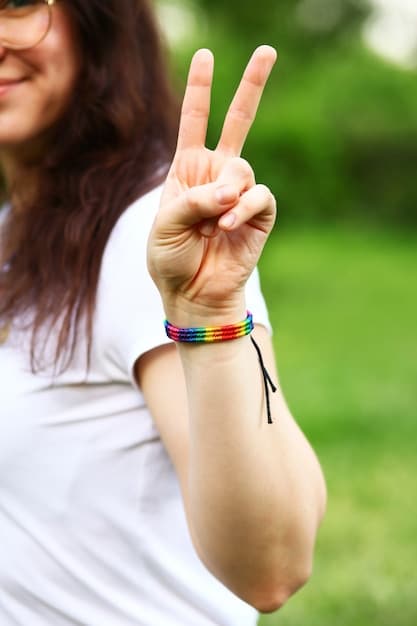 A close-up of hands clasped in meditation, with a rainbow flag bracelet visible on one wrist. The background is blurred, suggesting a focus on inner peace and solidarity.