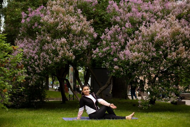 A person sitting on a park bench, practicing mindful breathing with their eyes closed. Surrounding them are lush trees and vibrant flowers.