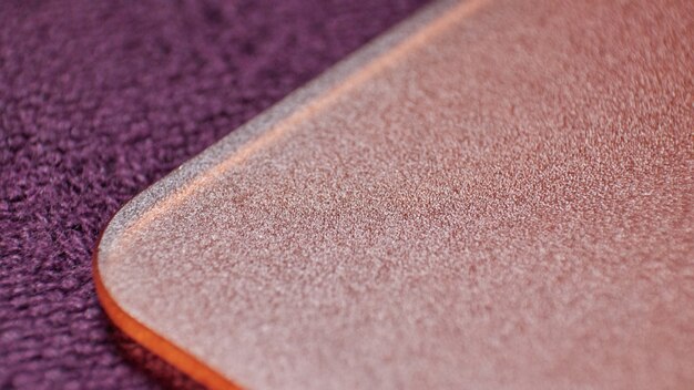 A close-up shot showcasing the textured surface of a natural rubber yoga mat. Water droplets are visible on the surface, highlighting the mat's grip and non-slip properties.