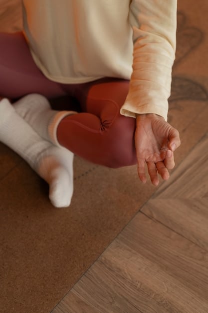 A close-up, slightly blurred image of hands gently resting on knees in a meditative pose. The background is a soft, natural setting, possibly a peaceful garden or a quiet corner of a room, emphasizing the tranquility and focus of meditation.