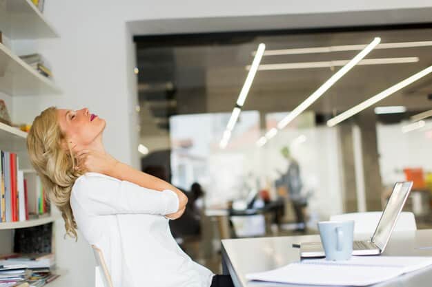 A person sitting at a desk, gently rolling their neck to the side. Their eyes are closed, and they appear relaxed. The background is a blurred office environment.