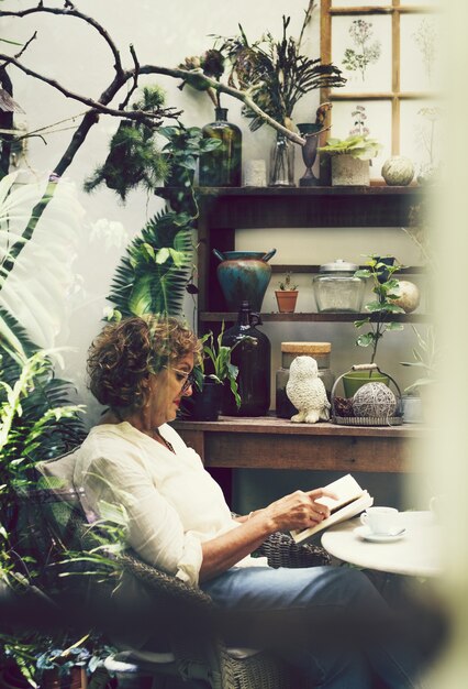 A person sitting in a comfortable chair, surrounded by books and plants, thoughtfully journaling. The scene conveys a sense of introspection and self-reflection.