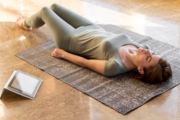 A person lying in Savasana on a yoga mat in a quiet, dimly lit room, with a blanket and eye pillow for added relaxation.