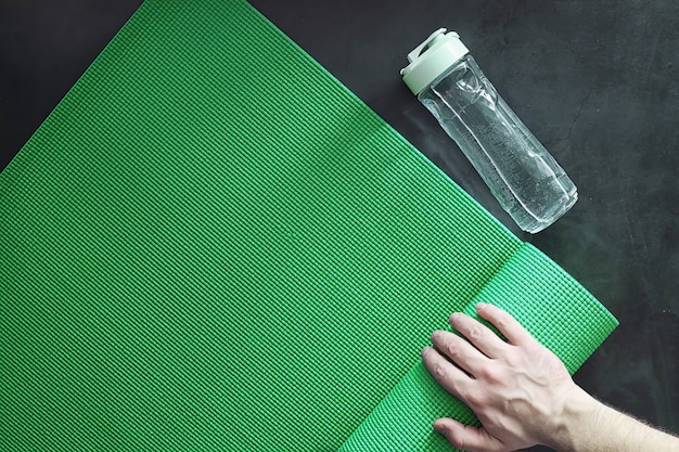A person’s hands demonstrating the grip of a yoga mat made from natural rubber. The mat is textured and eco-friendly.
