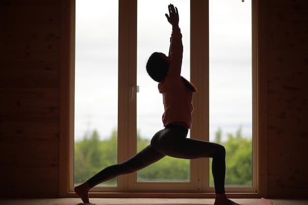 A person in Warrior II pose in a yoga studio, with focus on the alignment of the front knee over the ankle and the extended arms. Soft, natural light filters through the windows.