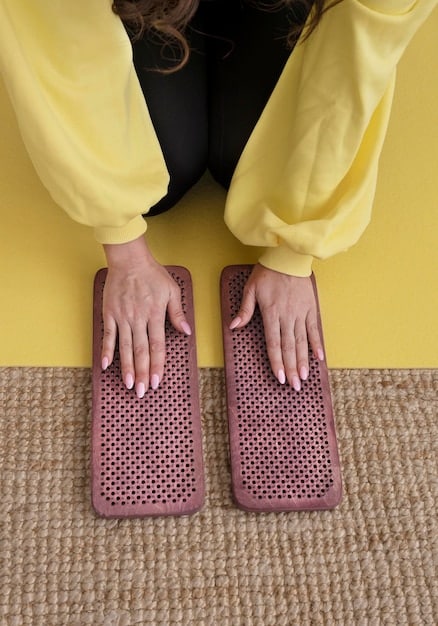 A close-up of a person's hands pressing into a intricately designed yoga mat, showcasing vibrant spring colors and a non-slip surface.