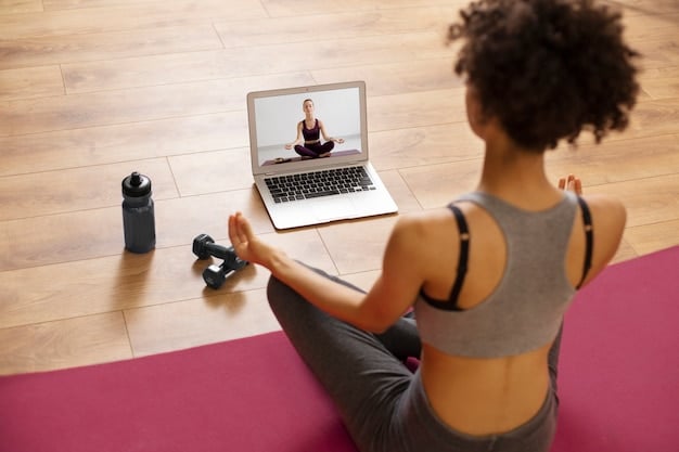 A yoga instructor leading an online class via webcam. The instructor is demonstrating a pose, and several participants are visible in smaller windows on the screen. The setting is a comfortable home environment, with yoga mats and props visible in the background.