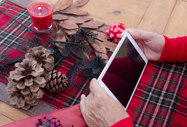 A visual representation of setting digital boundaries: hands gently pushing away a screen with holiday-themed notifications and messages, symbolizing the act of disconnecting to preserve personal peace during the holiday season.