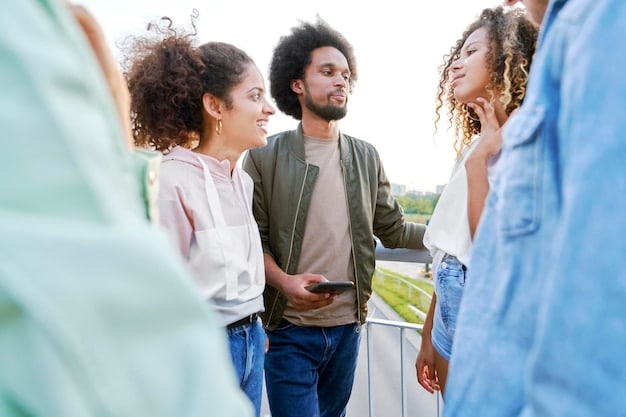 A group of diverse people laughing and talking together in a park, symbolizing strong social connections and support networks. The sun is shining, creating a warm and inviting atmosphere.
