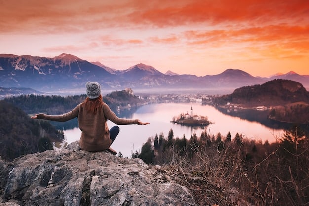 A wide-angle shot of a person practicing yoga on a mountaintop, overlooking a vast and serene landscape, with the rising sun casting a golden glow.