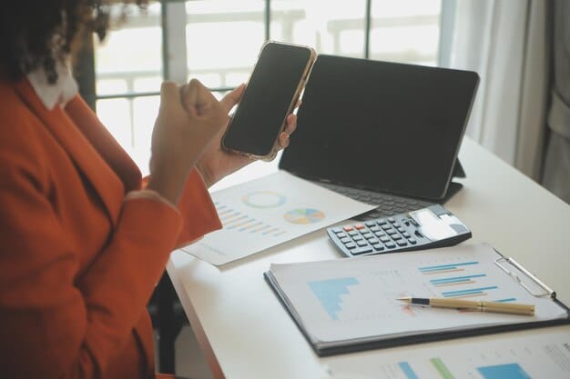 A person is using a budgeting app on their tablet while sitting at a desk with a calculator and financial documents. The scene conveys a sense of control and organization.