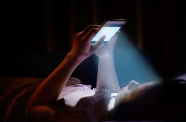 A person placing their smartphone on a nightstand in a dimly lit bedroom, showing a conscious effort to disconnect from technology.