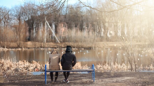 A person sitting alone on a park bench, looking distressed. Soft, muted colors with a shallow depth of field emphasize the feeling of isolation and stress caused by relationship problems.