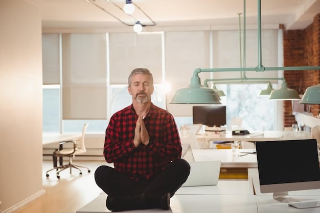 A person sitting in a bright office, meditating with eyes closed and hands resting gently on their knees. The background shows a clean desk with a laptop and a plant. There is a ray of sunlight falling on the person, highlighting the peaceful atmosphere