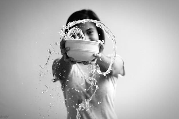 A person washing dishes mindfully, focusing on the sensations of the water and the texture of the dishes.