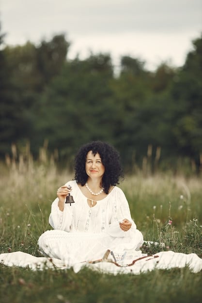 A person sitting in a quiet garden, with their eyes closed, palms upward as if receiving, and a gentle smile on their face. The image conveys a sense of peace and mindfulness amidst nature.