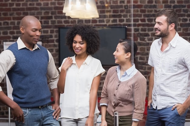 A diverse group of people standing in a circle, smiling and engaged in a lively conversation, symbolizing communication and support. The background is a brightly lit, modern office space.