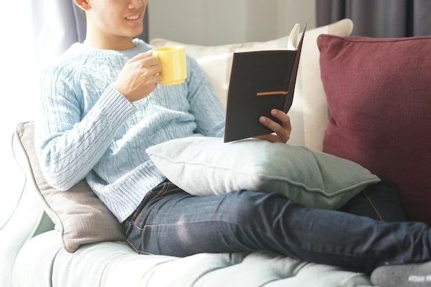 A person writing in a journal while sitting comfortably on a sofa with a cup of tea. They are surrounded by soft lighting and cozy blankets, creating a warm and inviting atmosphere. The focus is on the act of journaling as a form of self-reflection and emotional processing.