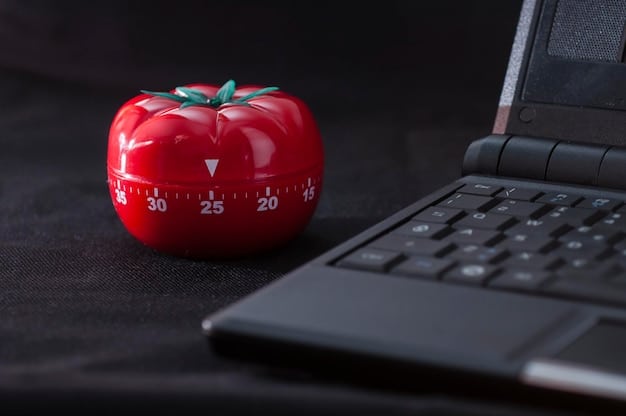 A person using the Pomodoro Technique with a timer on their desk, surrounded by work materials.