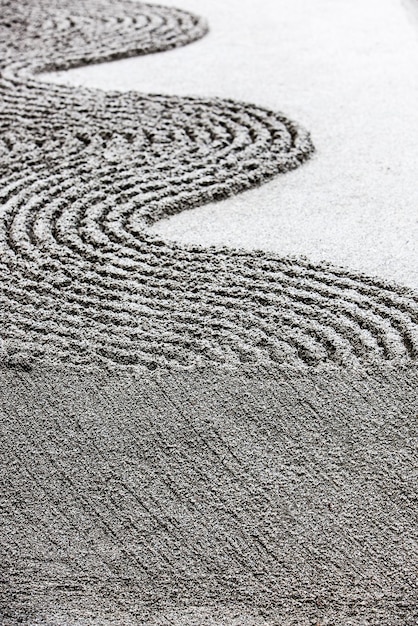 A close-up of meticulously raked gravel in a zen garden, showcasing the patterns and textures that promote mindfulness.