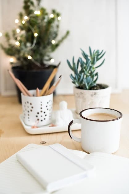 A clean, minimalist desk setup with a plant, a notebook, and a cup of tea. Soft, natural light is coming in from a nearby window.