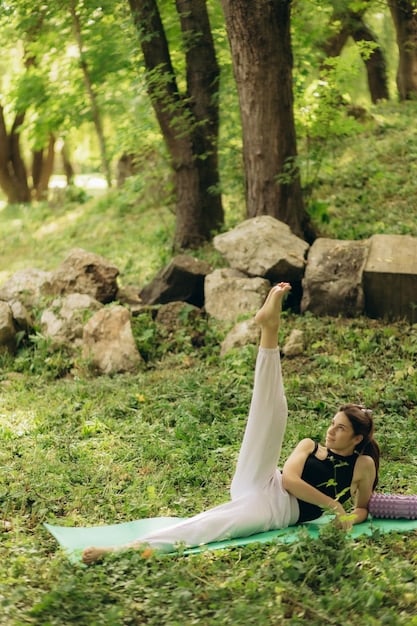 A person practicing yoga outdoors in a park, surrounded by trees and greenery, demonstrating a connection between movement and nature.