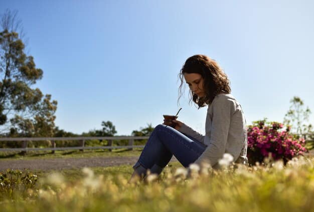 A person writing in a gratitude journal outdoors in a sunlit garden, focusing on positive thoughts and reflections. The garden is lush with greenery and colorful flowers, creating a peaceful and inspiring environment.