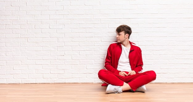 A person sitting cross-legged, eyes closed, in a bright and airy room. They are surrounded by neatly arranged shelves with a few carefully selected items on display, reflecting minimalist aesthetics and a peaceful state of mind.