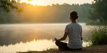 Person meditating by a lake at sunrise, symbolizing inner peace and personal growth.
