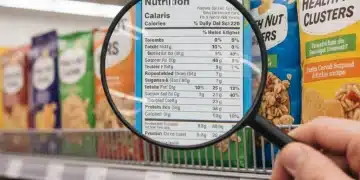 Primer plano de etiquetas nutricionales en envases de alimentos en un supermercado de España, destacando la información clave.